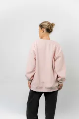 Buzo oversize de cuello redondo, confeccionado en algodón suave con interior frizado. Presenta un diseño de líneas simples, corte relajado y mangas largas con puños ajustados.
