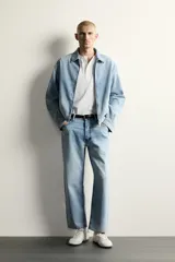 Jeans de corte regular cropped confeccionados en denim ligero de algodón. Presentan un diseño de cinco bolsillos con efecto lavado, tiro medio y cierre frontal con botones.