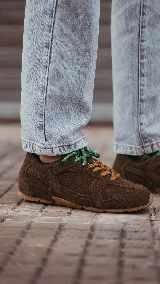 Zapatillas urbanas de cuero celeste y mesh gris, con suela de goma y doble juego de cordones intercambiables en color verde y blanco.