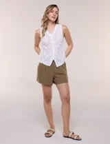 Blusa sin mangas blanca de puro algodón liviano, con escote en V, bordados florales en relieve, cartera frontal abotonada y terminaciones con festón calado.