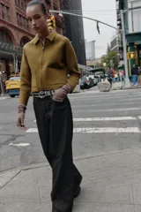 Chaqueta de punto de corte recto, color verde oliva, con cuello solapa, cierre frontal con cremallera y bolsillos delanteros de plastrón.