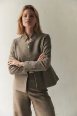 Chaqueta corta con cuello solapa, manga larga con coderas aplicadas, cierre frontal con botones y bolsillos ojal. Con forro.