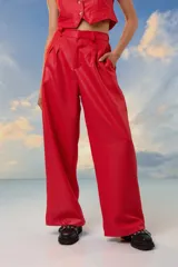Pantalón rojo de crepe de sastrería con lurex, tiro alto, corte sastrero, pinzas delanteras y pretina elastizada en la espalda.