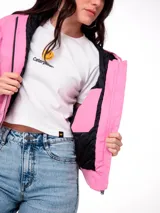 Chaqueta corta de lona color rosa, con capucha ajustable, cierre frontal y forro interior acolchado negro. Presenta un parche con el logo de la marca en el pecho.