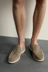 Mocasín destalonado de hombre fabricado en piel con acabado en gamuza, color marrón claro, con detalle de bordón en la parte superior, horma redonda y suela plana a contraste.