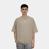 Remera de corte oversize color beige, con estampa gráfica en la espalda que incluye el logo HC y detalles tipográficos en color crema.