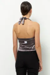 Top negro de satén con cuello halter y espalda descubierta.