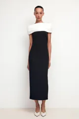 Zapato de tacón color blanco hueso, con punta fina, tiras finas con hebillas doradas y tira trasera ajustable con hebilla. Tacón fino.