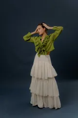 Camisa verde de manga larga, con volados frontales y detalles de puntilla bordada.