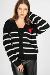 Saco negro con rayas horizontales blancas, escote en V, cierre con botones y un corazón rojo bordado en el pecho.