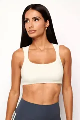 Top deportivo de poliamida con escote redondeado y espalda tipo nadador. Cuenta con forro interno y abertura para colocar almohadillas, ofreciendo soporte y libertad de movimiento.