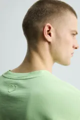 Camiseta de manga larga color verde lima, corte regular fit y cuello redondo. Presenta un bordado discreto en la espalda.