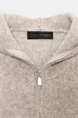Sudadera de lana con capucha, manga larga y cierre frontal con cremallera. Diseño de punto con acabado jaspeado.