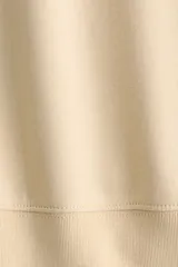 Buzo oversized de cuello redondo con hombros caídos, confeccionado con interior cepillado suave. Presenta puños y bajo en punto acanalado.
