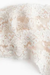 Pack de dos bombachas tipo colaless confeccionadas en encaje floral con terminaciones festoneadas y detalle de pequeño lazo central.