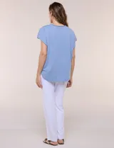 Remera de silueta amplia y relajada confeccionada en algodón y poliéster, de color verde, con escote a la base y mangas cortas de hombro caído. Presenta dobladillo enrollado y ruedo curvo.