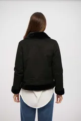 Campera de gamuza sintética negra con interior y detalles de piel sintética en cuello, puños y ruedo. Cuenta con cierre frontal y cuello con tira ajustable.