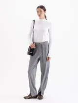 Pantalón de punto liso color gris, de corte recto y silueta relajada. Presenta cintura alta con cinto integrado, bolsillos aplicados en el delantero y tajos frontales en el ruedo.