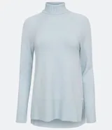 Suéter de tejido de punto color beige con cuello alto, mangas con corte raglán y puños y ruedo acanalados. Presenta un diseño clásico y cómodo con el ruedo trasero ligeramente más largo.