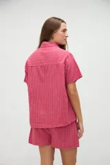 Camisa de manga corta de algodón con diseño a rayas en tonos amarillo y blanco, calce holgado, cuello solapa y bolsillo aplicado en el pecho.