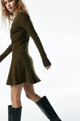 Vestido corto de punto acanalado color verde militar, con escote redondo, cierre frontal parcial con botones, manga larga, cuerpo entallado y falda evasé con vuelo.