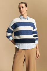 Sweater de tejido de punto con diseño de rayas horizontales en tonos azul y blanco. Presenta cuello redondo, puños y ruedo acanalados, con un sutil patrón de relieve en el tejido.