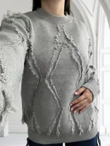 Sweater gris de tejido de punto con cuello redondo y mangas largas. Presenta un diseño con rombos y flecos.