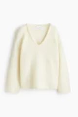 Buzo oversized de punto suave con mezcla de lana y mohair, con escote en V pronunciado y hombros caídos. Presenta terminaciones acanaladas finas en el cuello, los puños y el ruedo.