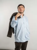 Camisa de corte clásico confeccionada en algodón, con diseño de cuadros finos en tonos neutros. Presenta cuello con botones, bolsillo frontal con logo bordado y cierre de botones.