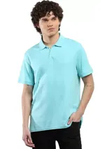 Chomba de manga corta color celeste, con cuello y tapeta de dos botones. Presenta un logotipo tonal de Calvin Klein en el pecho.