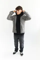 Sobrecamisa escocesa de paño en tonos blanco, negro y marrón. Corte recto con cuello camisero, cierre frontal con botones, dos bolsillos de parche en el pecho y puños abotonados. Disponible en tallas S a XL.