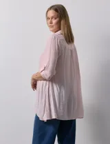 Camisa larga de rayón, con cuello clásico, cierre frontal con botones y mangas regulables con presilla. Presenta un diseño holgado con tajos laterales en el ruedo.