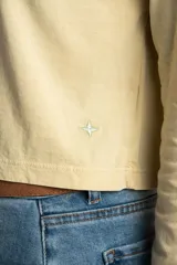 Remera color amarillo pastel de algodón peinado, corte recto y mangas largas.