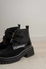 Borcego de cuero color suela con puntera redondeada, cierre mediante tiras de velcro y suela track de goma negra.
