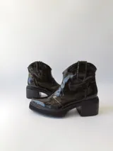 Botas texanas negras de cuero charol con caña baja, punta fina y tacón cuadrado.