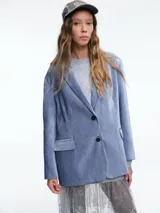 Blazer de pana en color azul, con solapas clásicas, cierre frontal de dos botones y bolsillos laterales con solapa.