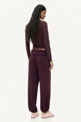 Pantalón globo color bordó, de corte holgado en punto de viscosa, con cintura elástica ancha fruncida y piernas fruncidas con elástico en los tobillos.