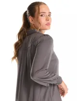 Camisa de satén color celeste, con cuello clásico, cierre frontal con botones y mangas largas con puños abotonados.