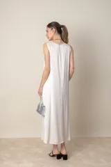 Vestido midi sin mangas, color crudo, de corte suelto y confeccionado en tejido de rayón/viscosa.