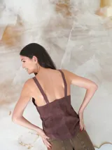 Top de cuero gamuzado color marrón, con escote en V y cierre frontal mediante cordones entrelazados.