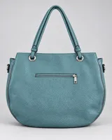 Cartera color celeste de diseño amplio y base redondeada, con textura granulada, costuras geométricas, doble asa de hombro y detalles metálicos con cierres.