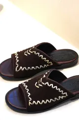 Sandalias planas de cuero y gamuza marrón con costuras decorativas en zigzag de color beige en la capellada.