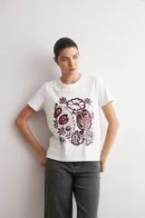 Remera blanca de manga corta con estampa damasco floral en tonos bordó y negro en el frente.
