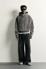 Sudadera con capucha de corte relajado, confeccionada en tejido de algodón con efecto lavado. Presenta manga larga, bolsillo frontal tipo canguro y terminaciones en rib.
