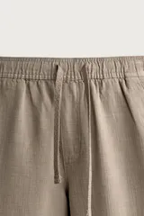 Pantalón de corte regular fit confeccionado en tejido mezcla de algodón, con cintura elástica ajustable mediante cordón, bolsillos laterales y bolsillos traseros de vivo.