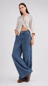 Pantalón de jean azul de tiro medio con corte de pierna ancha y diseño de cinco bolsillos con costuras a contratono.