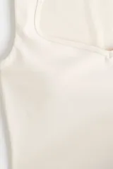 Top deportivo cropped H&M Move en tejido funcional color beige con tecnología SculptMove™ y DryMove™. Presenta escote corazón, soutien incorporado con relleno extraíble y corte ajustado.