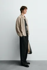 Sobrecamisa de hombre color beige, confeccionada en tejido de crochet con estructura abierta, cuello solapa, manga larga y cierre frontal de botones.