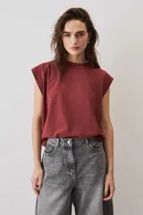 Remera sin mangas bordó con hombreras marcadas y cuello redondo.
