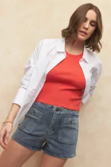 Short de jean azul con cuatro bolsillos delanteros con solapa y botón.